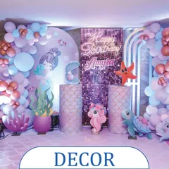 A complete mermaid-themed decor setup for a birthday party. This backdrop includes a shimmering sequin panel, a neon "Happy Birthday" sign, and adorable sea creature props to create a perfect underwater photo zone.