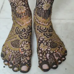 A detailed view of a heavy bridal foot design, with intricate patterns covering every part of the feet.