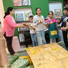 An instructor helps students arrange their newly made solar system models, a highlight of our astronomy-themed workshops.
