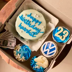 This custom birthday hamper was designed for someone who loves the color blue and travel. It includes a personalized bento cake and cupcakes with themes like the Volkswagen logo, starfish, and even edible money.