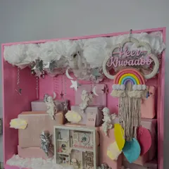 This angle highlights the depth and layering within the baby announcement box, with hanging crystals, fluffy clouds, and carefully placed gifts creating a three-dimensional effect.