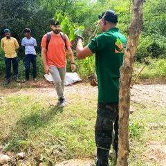 Our team members are always ready to share their knowledge. Here, a staff member is showing a volunteer the correct way to handle a sapling during a plantation drive at Jaunapur City Forest.