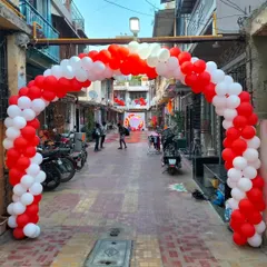 A large red and white balloon archway we built at the entrance of the street for the 25th-anniversary party, creating a grand welcome for all the guests.