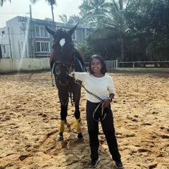 A student stands proudly with her horse after a lesson. Building this connection is a key part of the learning process from day one.
