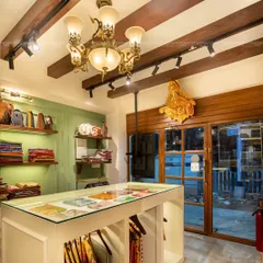 For this traditional sari boutique, I wanted to create an experience, not just a store. I designed the space to feel like a modern 'haveli', using a classic chandelier, wooden beams, and thoughtful displays to transport customers and honor the rich heritage of Indian textiles.