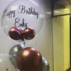 A personalized bubble balloon for Enky's birthday. The clear balloon with custom vinyl text is filled with smaller chrome balloons, creating a unique and modern gift.