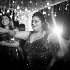 A candid black and white shot of a guest dancing with abandon at the Sangeet, capturing the pure joy of the celebration.