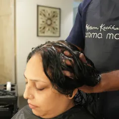 A close-up of our hair spa treatment in progress. The therapist thoroughly works the nourishing product into the hair and scalp, ensuring every strand receives the benefits.