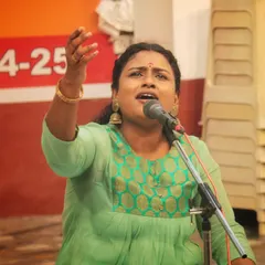 The expression of pure devotion on a student's face as she sings a bhajan at the temple.