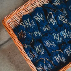 Beautifully embroidered velvet pouches with the couple's monogram, serving as elegant and personalized wedding favors for guests to take home.