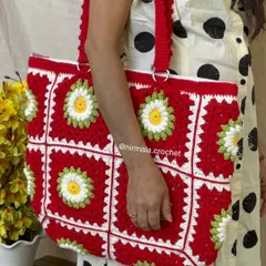 A model showcasing the generous size and comfortable straps of the red daisy tote. It’s a practical and stylish choice for daily use.