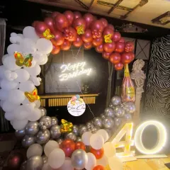 A chic 40th birthday decoration with a balloon ring in red, white, and silver, a neon sign, and a light-up number '40'.