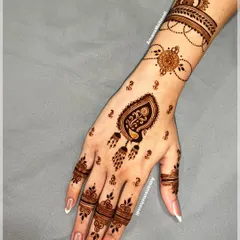 An elegant Arabic-inspired design on the back of the hand. The pattern uses open space to create a flowing, vine-like effect from the wrist to the fingers.