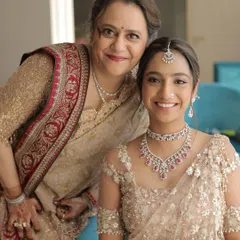 A glowing mother and daughter duo. The mother's makeup features a soft, luminous base and defined eyes, a timeless look that enhances her features without feeling heavy.