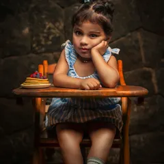 A little philosopher with her pancakes. This creative portrait captures a thoughtful, funny moment, telling a story with a single look.