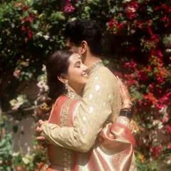 A warm, heartfelt hug between the couple, set against a vibrant wall of bougainvillea. The bride's joyful expression says it all, a perfect candid moment.