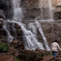 A solo shot of the groom exploring a majestic waterfall. Our pre-wedding shoots often include individual portraits that capture a sense of adventure and wonder in stunning natural landscapes.