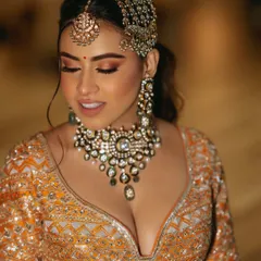 A beautiful close-up of the bride, her makeup and jewelry perfectly complementing her orange and silver lehenga.