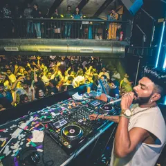 A high-angle shot showing me on the mic, overlooking a packed dance floor. I make sure to engage with every corner of the room.