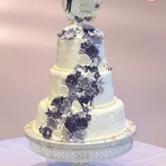 This three-tiered wedding cake was a dream to create. Adorned with a cascade of hand-made purple sugar flowers, it’s a perfect example of how I craft elegant centerpieces for your biggest moments. Each tier can be a different flavor to delight all your guests.