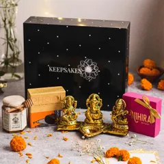 The "Diya" hamper is a complete festive package. It includes a beautiful brass Ganesha, Lakshmi, and Saraswati idol set, premium honey, and gourmet sweets, all presented in my signature black keepsake box.