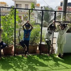 On World Yoga Day, children practice the tree pose in our outdoor area. Yoga helps them develop balance, concentration, and a connection between their mind and body.