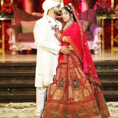 A classic, romantic pose on the reception stage. The groom's gentle kiss on the bride's forehead is a timeless expression of love.