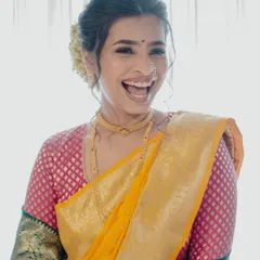 The pure, uninhibited joy of a bride on her wedding day. Her minimal makeup, featuring a simple bindi and glowing skin, perfectly complements her traditional Paithani saree.