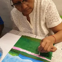 Here is Anju, completely absorbed in her painting. During her radiation therapy, she found that focusing on the canvas and the flow of colors provided a much needed escape and a sense of peace. This is the process of art therapy in action.