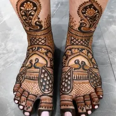 A stunningly intricate foot mehandi design, featuring peacocks and paisley patterns with full coverage on the toes.