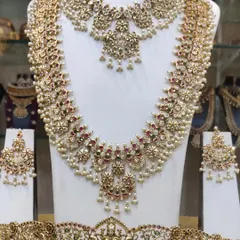 A gorgeous guttapusalu-inspired set, featuring clusters of pearls. This set includes a choker, a long haram, and a Lakshmi-motif vaddanam.