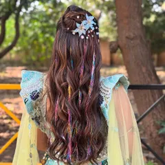 For a fun, carnival themed Mehendi, I created this half updo with flowing waves and added colorful thread extensions and whimsical blue floral clips. This style is all about expressing personality and embracing a vibrant, playful theme.