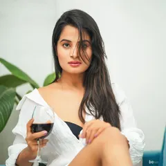 A relaxed and confident lifestyle portrait. The simple white shirt and glass of wine create a sophisticated yet casual vibe, perfect for capturing a moment of quiet confidence.