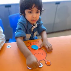 Carefully placing the eyes on his alien craft, this child is engaged in a hands-on activity that boosts creativity and fine motor skills.