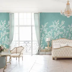 A bedroom should be a sanctuary of serene elegance. In this space, we used a delicate botanical wallpaper to create a whisper of poetry, complemented by classic furniture and light, airy textiles for a timeless and restful atmosphere.
