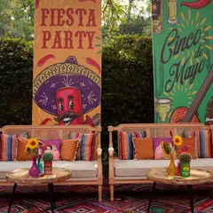 A fun and festive seating area with banners for the 'Fiesta Party' and 'Cinco de Mayo'. The decor is filled with bright colors, playful graphics, and comfortable seating for a relaxed party vibe.