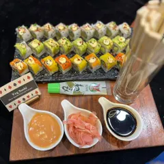 A colorful array of vegetarian sushi served on a slate platter for a Diwali party. The platter includes different types of rolls, showcasing a variety of flavors and textures.