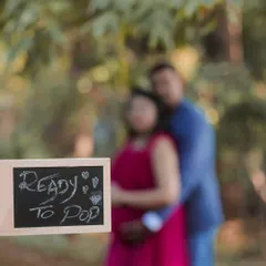 "Ready to Pop" says it all. This fun shot uses a chalkboard sign and selective focus to create a playful and artistic pregnancy announcement.