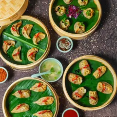 A feast of our handcrafted momos, steamed to perfection in traditional bamboo baskets. This spread shows the variety we offer, each dumpling filled with spiced ingredients and served with our signature clear soup and dipping sauces. This is the heart of Himalayan comfort food.