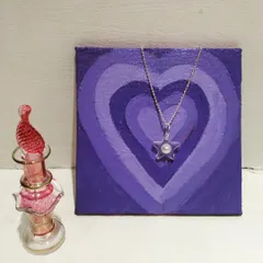 A star-shaped resin pendant with a small pearl at its center, offering a simple and elegant design for everyday wear.