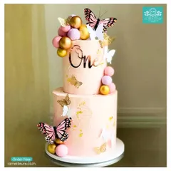 Celebrating a first birthday is a huge milestone, and I can create the perfect themed cake to match. This two-tiered butterfly cake in soft pink is decorated with gold and pink spheres, a custom 'One' topper, and delicate, colourful butterflies.