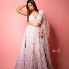 A full-length shot of a beautiful lavender lehenga against a pink studio background. This shows my ability to work with color and create a cohesive, glamorous look.