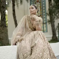 A quiet moment of reflection. This shot captures the complete bridal look, where the minimal makeup complements the intricate outfit and jewelry without overpowering the bride's natural elegance.