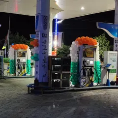 Here is a night view of two fuel pump stations decorated with tricolor balloon frames. The setup is designed to be visible and festive even after dark.