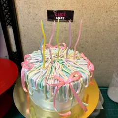A full view of my pastel ribbon cake design. This custom cake features delicate, multi-colored icing ribbons and bows for a playful and elegant look.