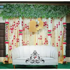 A beautiful Seemantham backdrop with hanging jasmine and rose garlands. The golden mother-child silhouette at the center is a perfect focal point for photos.