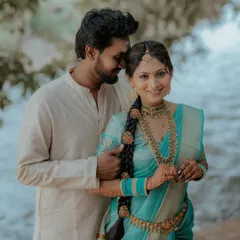 A sweet couple portrait by the water. The bride's vibrant blue saree and the groom's simple white dhoti create a beautiful contrast.