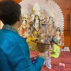 A devotee in traditional attire performs the Dhunuchi dance in front of the beautifully decorated Durga idol. It's a moment of pure, uninhibited worship.