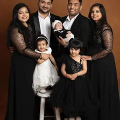 A full family portrait celebrating a new arrival. Coordinating in elegant black and white, this photo brings together parents, children, and relatives in a beautifully composed memory.