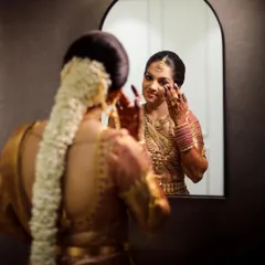 A beautiful shot of the bride looking at her reflection in the mirror, a quiet moment of contemplation before the ceremony begins.